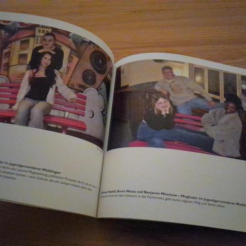 Im aufgeschlagenen Buch rechts und Link je ein Foto mit Mitgliedern des Jugendgemeinderats Waiblingen und der Pinken Bank der Demokratie.